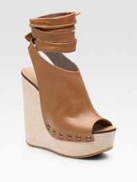 Chic, platform wedge style emboldened by a leather, wrap-around ankle strap. Wooden wedge, 5 Covered platform, 1½ Compares to a 2½ heel Leather upper Peep toe Leather lining Rubber sole Made in ItalyOUR FIT MODEL RECOMMENDS ordering one size up as this style runs small. 