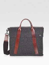 Sturdy and sleek in durable, water-resistant waxed wool, detailed with leather trim and custom die-cast black hardware.Handle and adjustable shoulder strapFlap and zipper closuresOrganizing pocketsInterior zipper pocketCotton liningWaxed wool exterior10¼ X 13½ X 4Imported