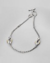 A graceful chain is punctuated by bold ovals of 18k gold and lacy silver medallions near the closure. Sterling silver and 18k yellow gold Length, about 18 Toggle closure Made in Greece
