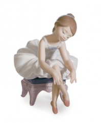 The picture of innocence, a young ballerina prepares for her debut in this darling figurine by Lladro. A white tutu and pink slippers complete the look in meticulously handcrafted porcelain.