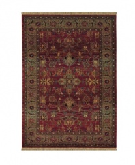 A truly charming interpretation of a traditional carpet, this rug features a center medallion ringed by palmettes and floral details in sage green, topaz and slate blue against a rich burgundy ground. Striated effects create the weathered look of handmade rugs in a stain-resistant, no-shed manmade fiber.