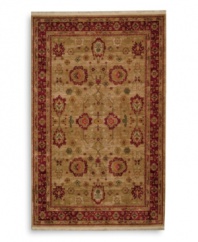 Inspired by an early 20th-century carpet woven in western Turkey, this oushak rug features an enlarged palmette trellis design surrounded by a rosette border in a rich palette of red, gold and green. Subtle gradations of color evoke the timeworn striated effect created by aged vegetable dyes. A patented wash process further harmonizes the colors into a rich vintage finish. Woven in the USA in premium worsted New Zealand wool for luxurious softness.