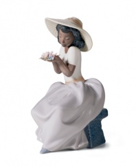 Signs of the season. An elegant woman rests on a park bench to enjoy the sweet smells and sights of spring in this delicately glazed Lladro collectible.