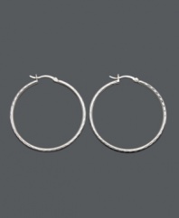 Traditional hoops with a cutting edge design. Set in sterling silver, these large hoops feature diamond-cut embellishments at the edges. Approximate diameter: 2 inches.
