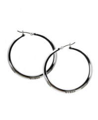 Make a style statement in the brand you love. GUESS hoops feature the company logo engraved on the surface. Set in silver tone mixed metal with jet plating. Approximate diameter: 1-1/2 inches.