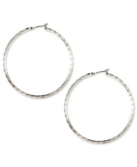 No accessory wardrobe is complete without a fabulous pair of hoop earrings, like these silver tone stunners from Anne Klein. The textured detailing adds an instant update to a classic look. Crafted in imitation rhodium mixed metal. Approximate diameter: 2 inches.