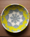 Hope shines among Rwanda's women artisans and in the vivid sun-yellow and slate-blue pattern that distinguishes this handcrafted basket. Filled with fruit or simply accenting a wall, it serves as daily inspiration for women everywhere.