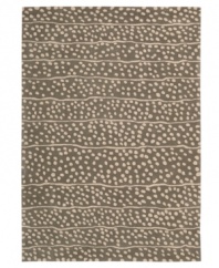 A blizzard of soft spots linger in between imperfect lines, creating beautiful harmony against a bold graphite ground. Hand tufted from 100% natural wool, this plush Calvin Klein rug is crafted using the cut-and-loop pile technique that creates a unique matte surface texture.