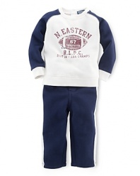 This coordinating athletic set includes a classic crewneck fleece pullover and matching sweatpant with contrast stripes for an authentic sporty look