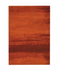 Abstract and dramatic, this handcrafted wool rug features a rich spectrum of shades from burnt orange tones to deep reds. The ethereal coloration pattern is reminiscent of a vivid sky at sunset. Luster-wash finish creates gently-diffused color variation.
