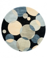 Abstract and absorbing, this rug features a multi-circle pattern in gray, taupe and an array of teal blues. Reminiscent of modern art paintings, it adds striking modernity and grace to your home. Hand-tufted and hand-carved of plush wool.