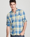 Effortless style in mellow plaid, this hip button-down shirt makes a great call for a weekend of lounging with friends.