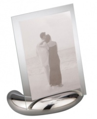 Keep memories fresh in the modern Elbow picture frame. A sculpted metal base turns back in an elegant curve, fitted with sheets of clear glass for displaying any photo, vertical or horizontal. Designed by Neil Cohen for Nambe.