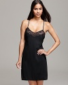 A spaghetti strap chemise with plunging neckline and an intricate floral lace hem, a sultry style from Calvin Klein.