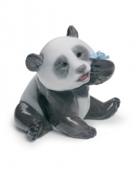 What a bear. This giant panda figurine inspects the intricate folds of a porcelain flower in this exquisitely handcrafted Lladro figurine.