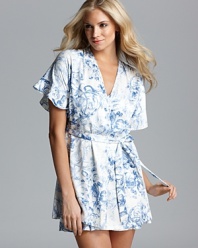 A short sleeve scroll/floral print wrap with ruffle trim and self tie at waist.